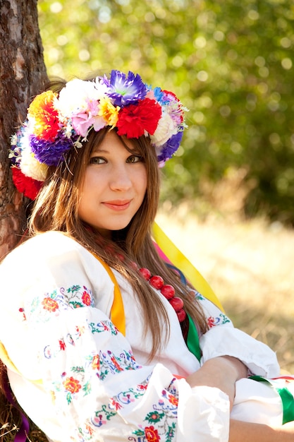 Menina eslava com coroa de flores no campo.