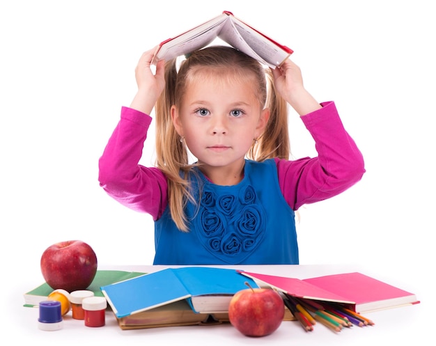 Menina esperta segurando um livro e lendo-o em um fundo branco