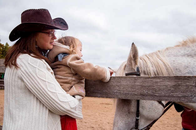 Menina está acariciando o cavalo