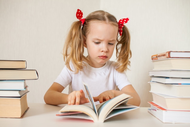 Menina está aprendendo lições em casa. Educação escolar em casa