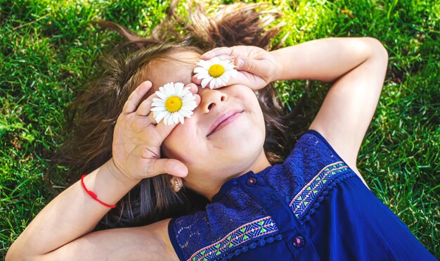 Menina está segurando flores de camomila nas mãos. Foco seletivo. natureza.