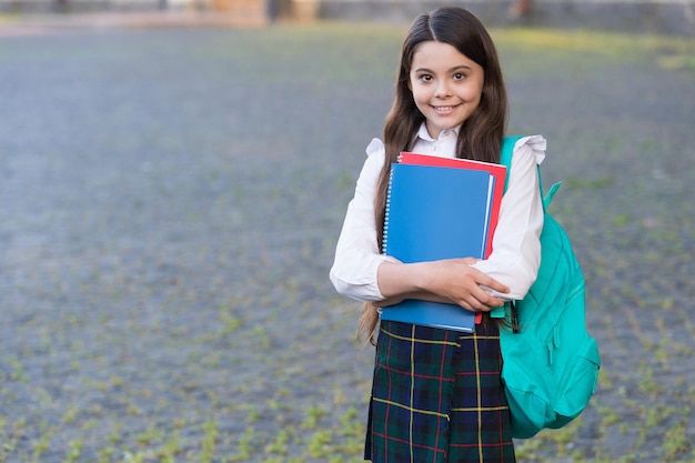 Menina estilo formal uniforme e mochila segurar livros, conceito de calendário escolar.