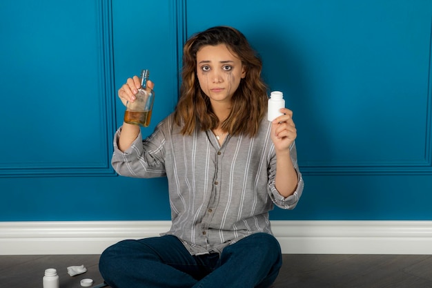 Menina estressada bebendo álcool e tomando pílulas. Foto de alta qualidade