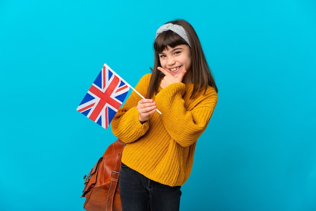 Menina estudando inglês isolada em um fundo azul feliz e sorridente