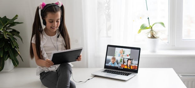 Foto menina estudando on-line usando seu laptop em casa.