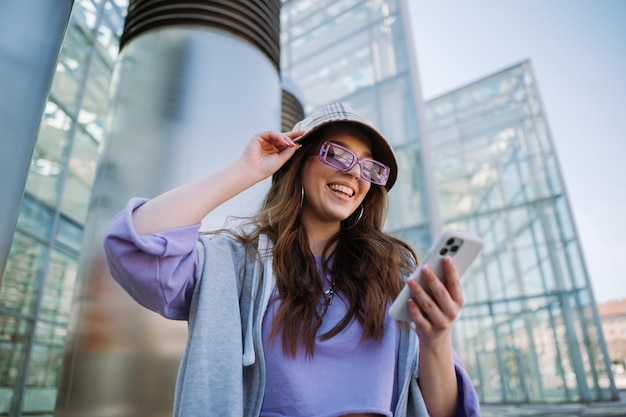 Menina excitada segurando e usando foto de alta qualidade do celular