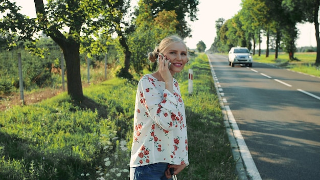 Menina falando no telefone enquanto pedindo carona.