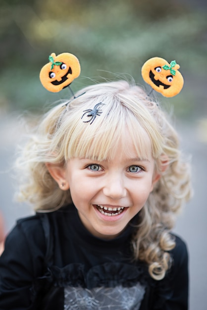 Menina fantasiada de bruxa comemorar o Halloween ao ar livre e se divertir.