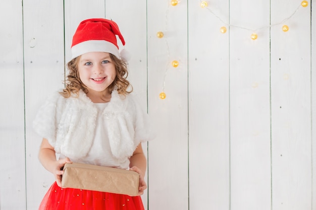 Menina fantasiada de Papai Noel com dom interior.