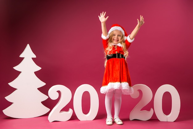 Menina fantasiada de papai noel fica com números 2020