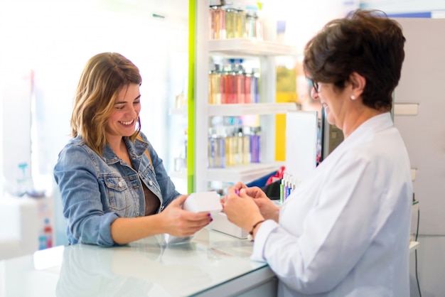 Menina farmacêutica, vendendo produtos para um cliente