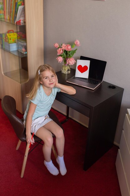 Menina faz cartão postal artesanal e sorrindo