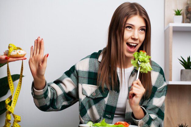 Menina faz uma escolha entre alimentos saudáveis e prejudiciais