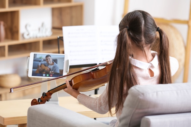 Menina fazendo aulas de música online em casa