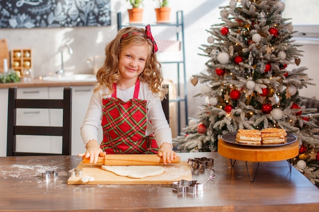 Menina fazendo biscoitos de natal na cozinha