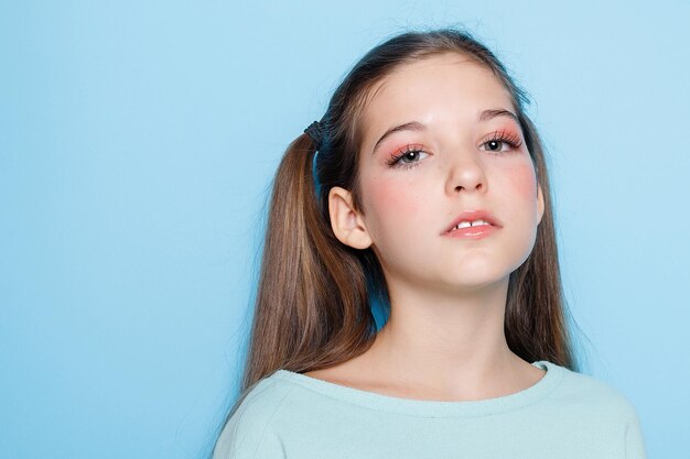 Foto menina fazendo careta e se divertindo na câmera isolada sobre fundo azul