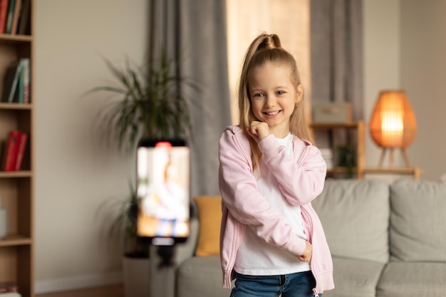 Menina fazendo vídeo no smartphone para blog de moda dentro de casa