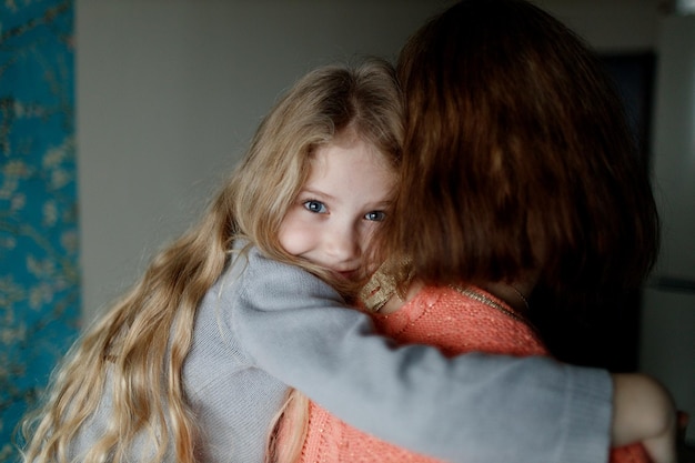 menina feliz abraçando a mãe