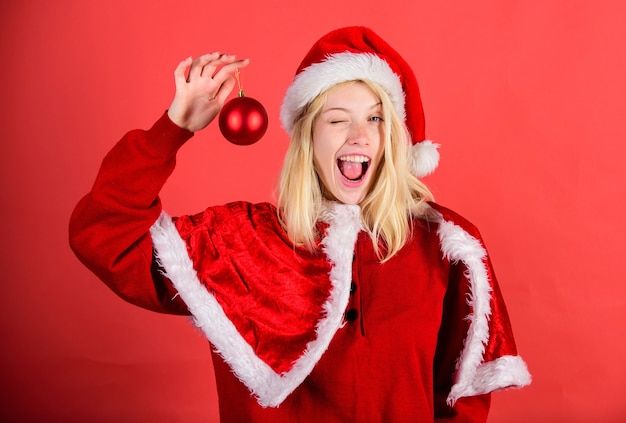 Menina feliz alegre usar fantasia de papai noel comemorar decoração de bola de espera de natal. conceito de boas festas. natal de ano de época favorita. aproveite a celebração com roupas adequadas para o baile de máscaras. feliz natal.