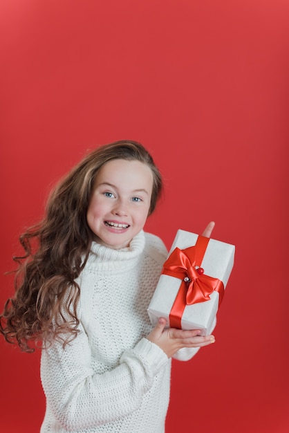 Menina feliz animado segurando a caixa de presente de Natal.