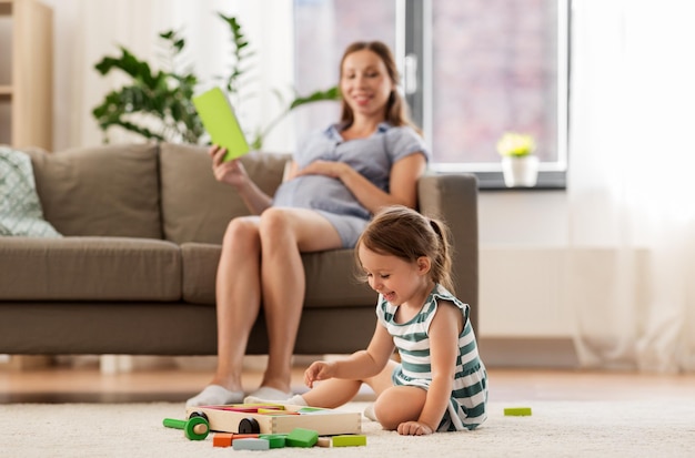 menina feliz brincando com blocos de brinquedo em casa