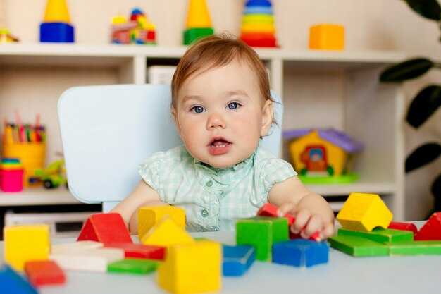 Menina feliz brincando com brinquedos em casa