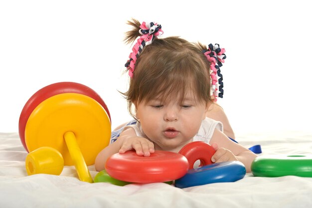 Menina feliz brincando com brinquedos em um fundo branco