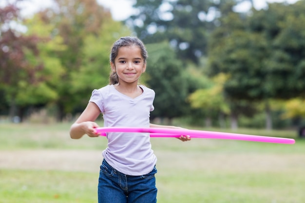 menina feliz brincando com hula hoops