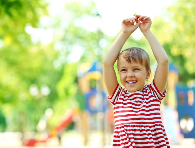Foto menina feliz brincando no parque perto do playground