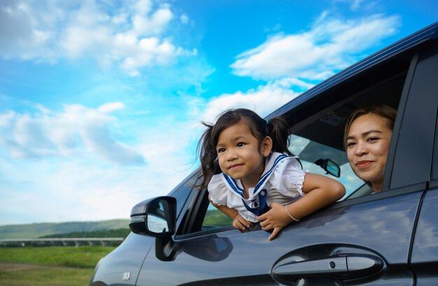 Menina feliz com a família sentada no carro.