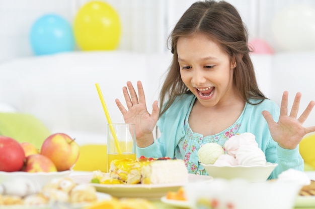 Menina feliz com bolo na festa de aniversário