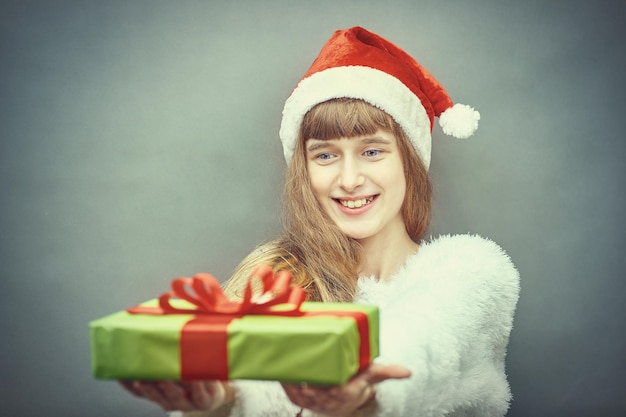 Menina feliz com chapéu de Papai Noel, tendo um Natal