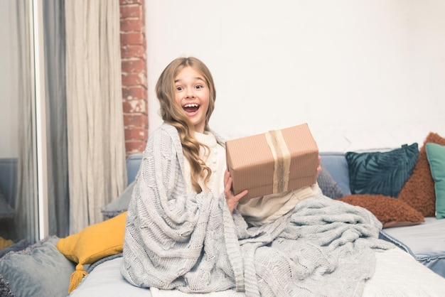 Menina feliz com presente nas mãos sonhando