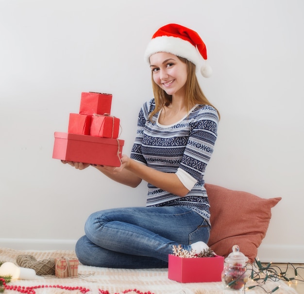 Menina feliz com presentes de natal dentro de casa