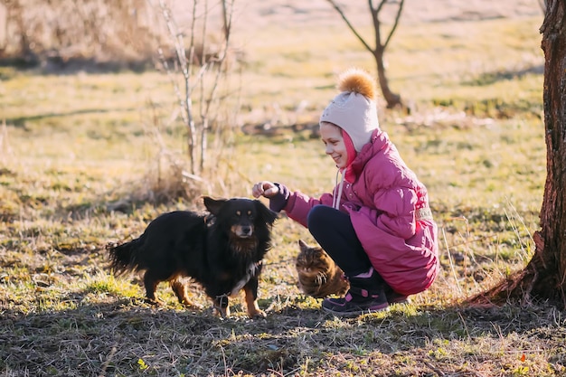 Menina feliz com seu cachorro no jardim rural