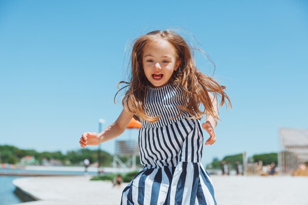 Menina feliz com síndrome de down se divertindo na praia