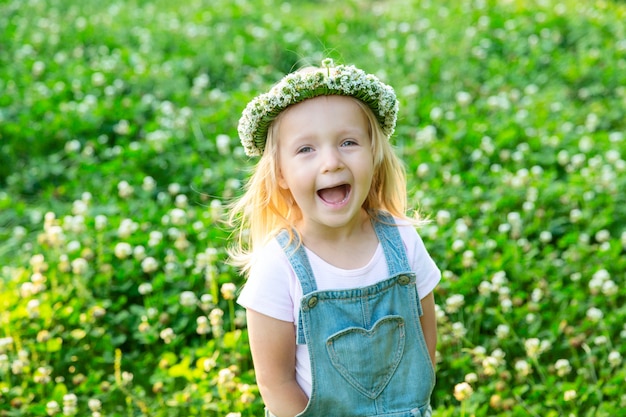 Menina feliz com uma coroa de trevo na cabeça dela sorrindo ao ar livre