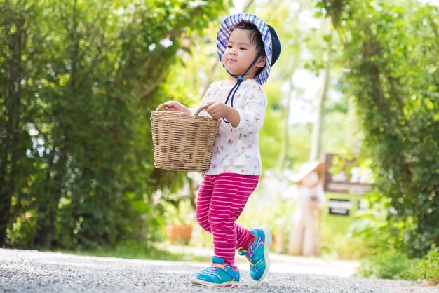 Menina feliz correndo com cesta na fazenda jardim