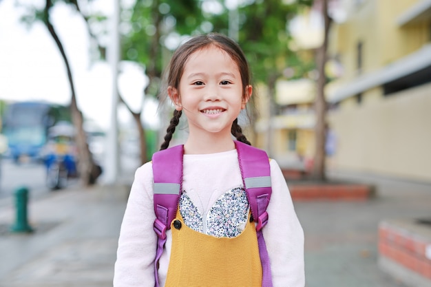 Menina feliz criança asiática andando com mochila