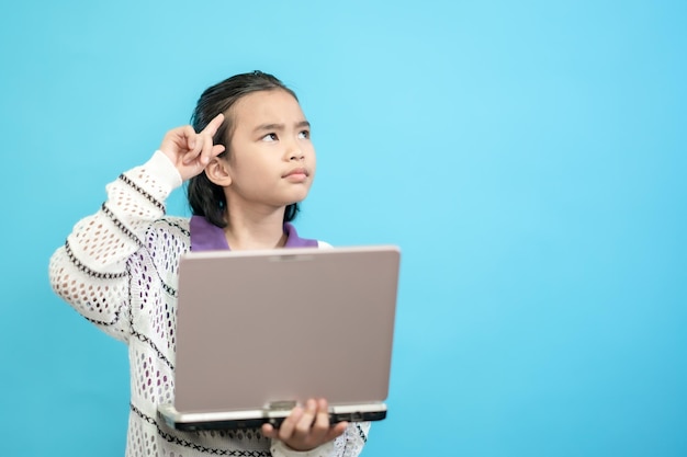 Menina feliz, criança asiática fecha pessoas fofas e alegres, segurando labtop olhando e sorrindo