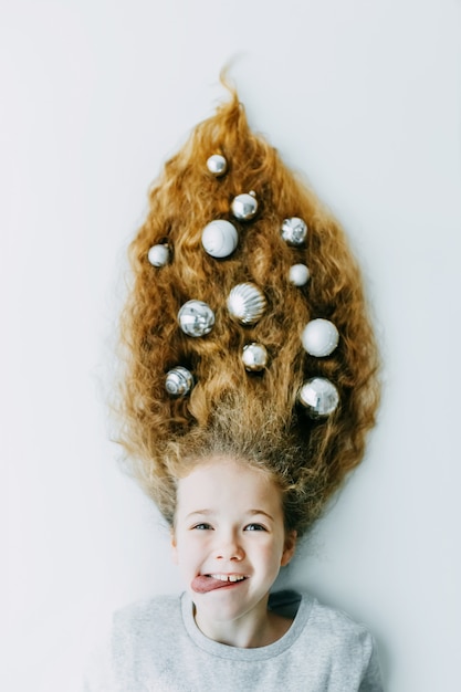 Menina feliz do inverno do Natal. Penteado de férias lindo ano novo e árvore de Natal
