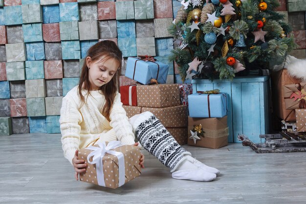 Menina feliz e sorridente com caixa de presente de Natal.