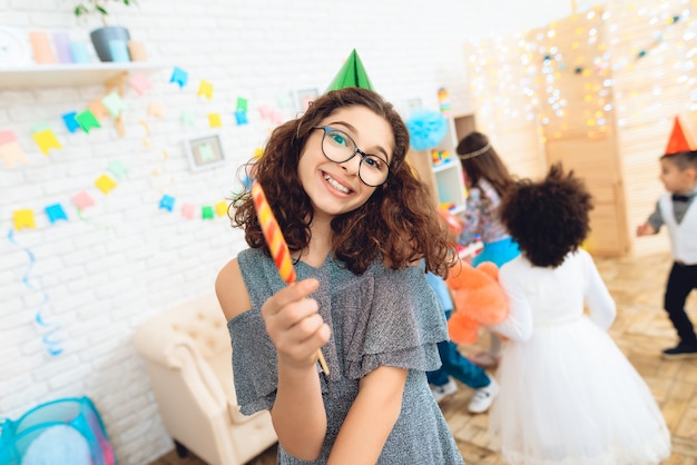 Menina feliz em copos com pirulito colorido