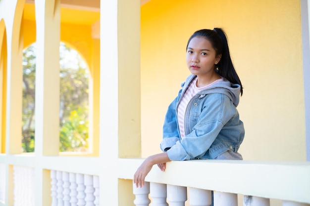 Menina feliz em pé na construção de fundo amarelo