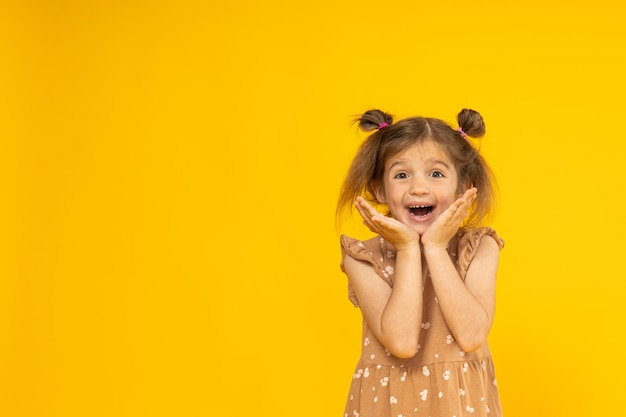 Menina feliz em um lugar de fundo amarelo para texto