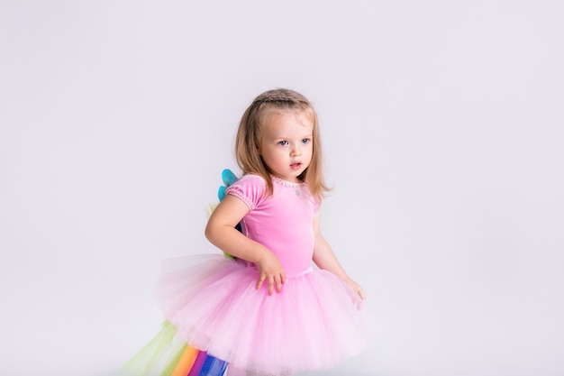 Menina feliz, engraçada, emocional, com fantasia de pônei rosa de Natal em branco