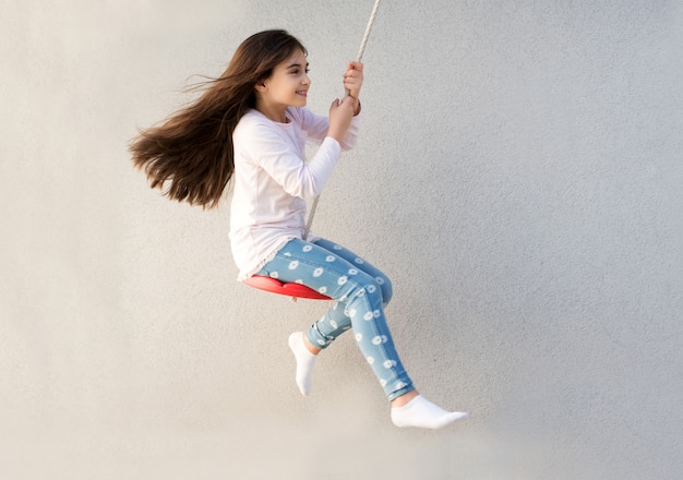 Foto menina feliz jogando em um balanço