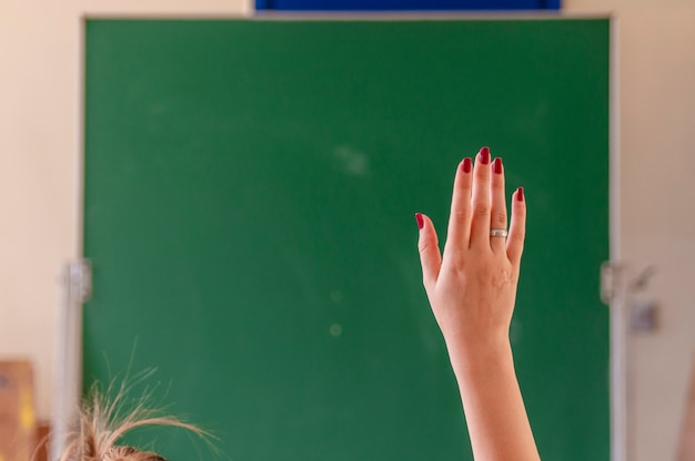 Menina feliz levantou as mãos na sala de aula