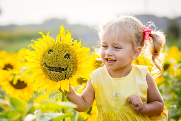 Foto menina feliz no campo de girassóis no verão linda menina em girassóis