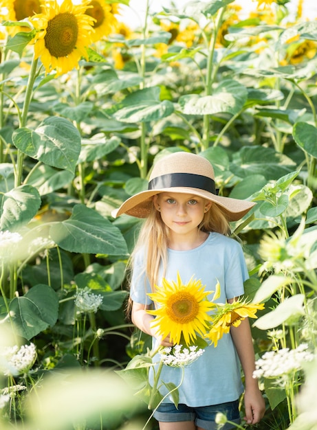 Menina feliz no campo de girassóis no verão.